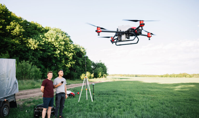 Modern drone flying over wheat grain field on sunny day. Agriculture industry